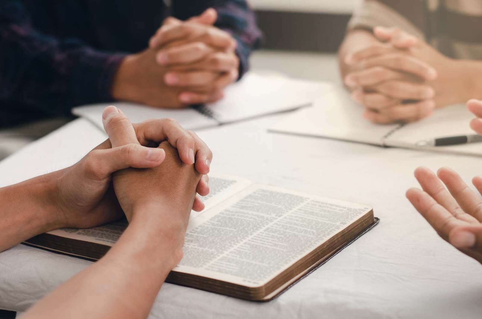 Group praying with bibles